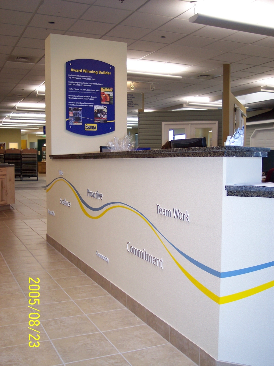 This is the front desk. I applied 3D lettering all along the outside as well as the business logos signature blue and yellow wave stripping. The photo shows one of several wall mounted signs i installed with 3D text, graphics, and business logo.